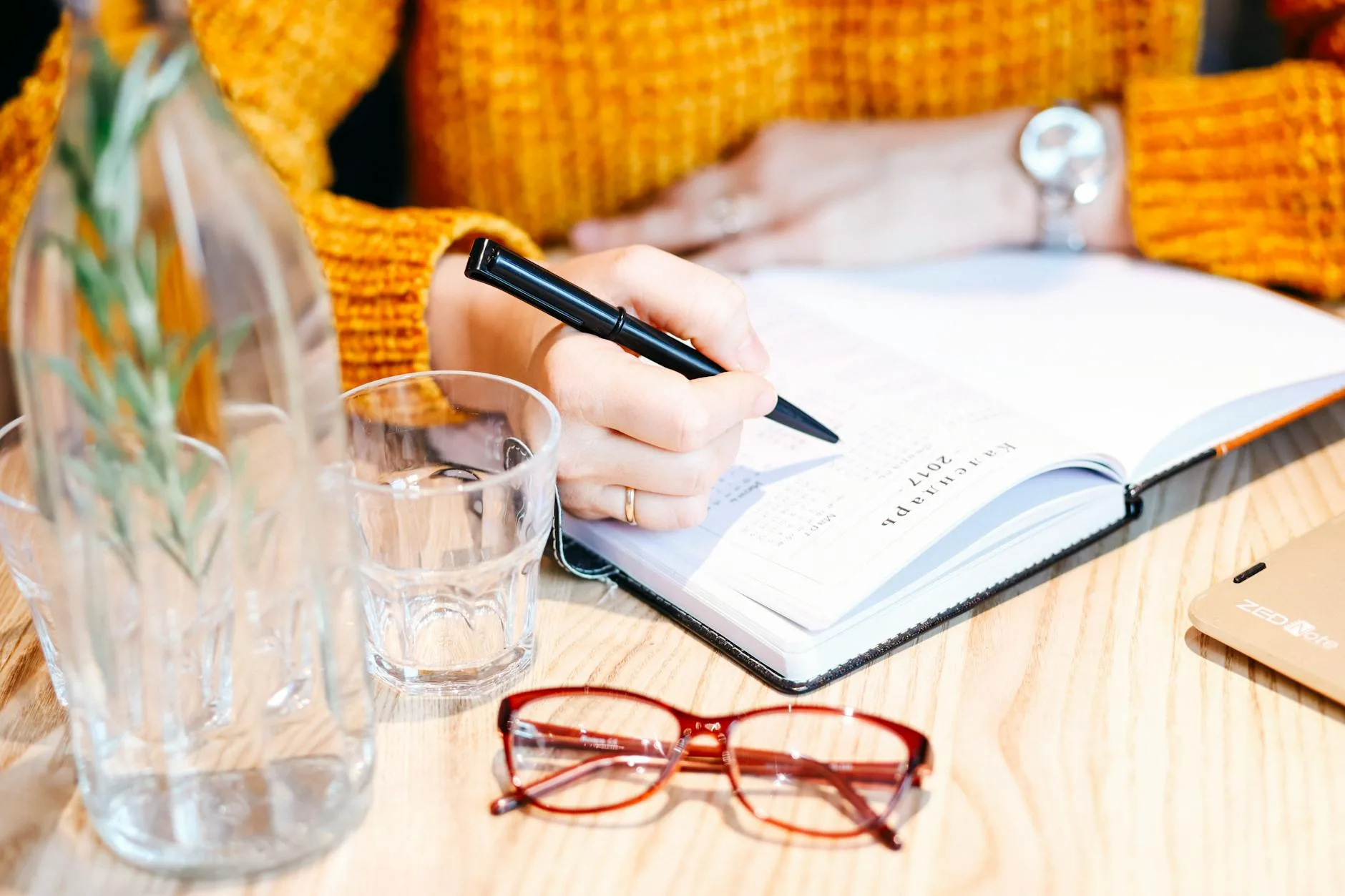 a female hands holding a pan and writing in notebook