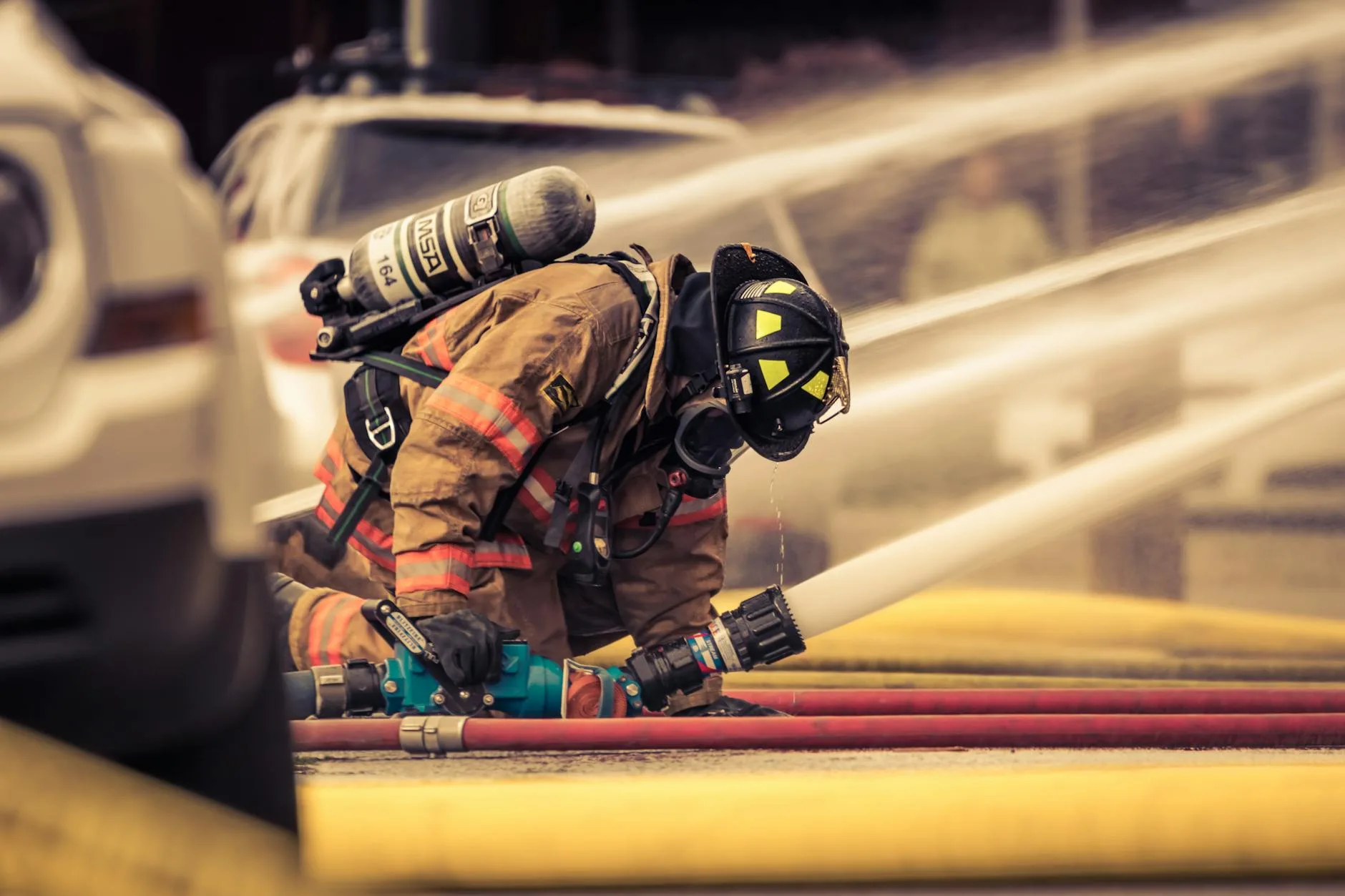 firefighter holding hose with water flowing